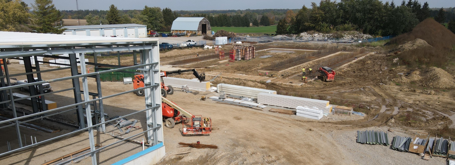 new municipal building being built, cement pad with steel structure and supplies laying on the ground near the building